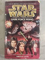 Front cover of the Star Wars Dark Force Rising paperback book showing main characters and spaceships.