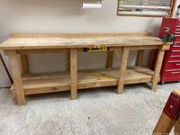Full view of 8 ft wooden workbench including lower shelf and front-integrated power strip