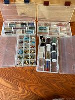 First photo showing two clear plastic bead organizers with multiple compartments filled with various small beads and tubes of beads.