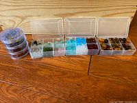 Wide view of the bead organizers showing compartment boxes and stacking jars with multicolor beads of various sizes and shapes