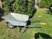 Side angle showing the metal tray with FORT embossed, single pneumatic tire, and yellow handle grips.