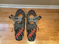Pair of Powderidge Crest 25 snowshoes showing top view with black decking, red 'CREST' logo and adjustable bindings