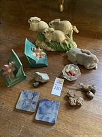Lot on wooden surface showing all items including ceramic animal figurines, floral bookends, blue and white stone coasters, frosted glass bowl, and small stones.