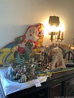 Wide view of entire collection showing large Santa Claus cutout, wooden pine trees, snowmen, and various diorama pieces arranged on tabletop.