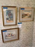 All three framed paintings hung on patterned wall