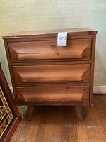 Front view of the 3-drawer chest showing drawer fronts with carved integrated handles.