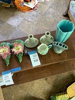 Overview of all seven ceramic and porcelain decorative pieces on wooden surface