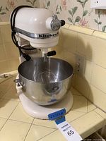 Full side view of KitchenAid Professional 6 stand mixer with stainless steel bowl attached on kitchen counter.