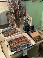 Wide view of hanging and bin-held necklaces showing assortment