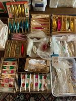 Overview of cardboard boxes and plastic bins containing various vintage glass Christmas ornaments