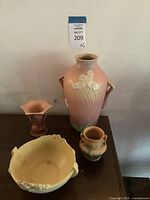 All four ceramic pieces displayed together on wooden surface