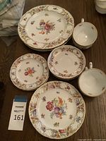 Overview of 8-piece partial tea set including 3 cups, 2 saucers, and 3 plates displaying floral motifs and gold trim by Schumann Bavaria.