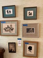 Six framed silhouette art prints arranged on a wall showing varied subject matter and frame sizes