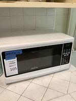 Full front view of the white Sunbeam microwave oven showing door, control panel, and digital display.