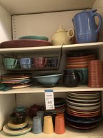 Three shelves of assorted Bauer Pottery pieces showing overall lot