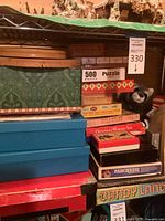Stack of puzzles and games including 500 piece puzzle, Christmas Manger Set, Parcheesi, Candy Land, and others