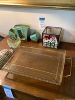Wide view showing all items together: metal tray, turquoise ceramic planter set, stained glass holder