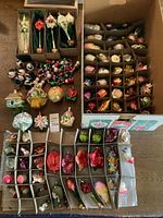 Overview of multiple partitioned storage boxes and trays filled with assorted glass ornaments, garlands and finials