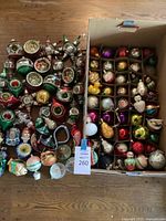 Full assortment of glass Christmas ornaments laid out next to storage box