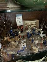 Multiple glass animal figurines displayed on glass shelf