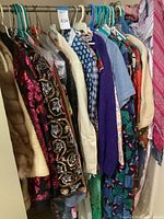 Wide shot of hanging vintage clothing items including Bullock's Pasadena fur stole and sequin-embellished jackets