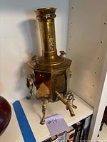 Front angle view showing octagonal body, legs, handles, spigot and chimney.