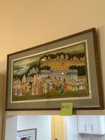 Full view of the framed Indian art piece showing the palace, hills, and procession scene with various figures and elephants.