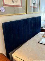 Side view showing navy velvet upholstered headboard and mattress edge