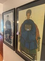 Side view of both framed Chinese ancestor portraits hung on a wall.