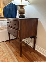 Side view of one nightstand with lamp showing overall form and condition