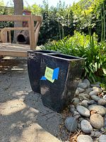 Two vintage black ceramic planters from an angle showing their rectangular tapered shape and glossy surface.