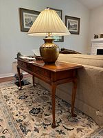 Side view of vintage wooden table credenza showing both drawers, carved details, and elegant curved legs.