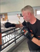 Man training with boxing gloves striking a heavy bag in gym