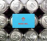 Gift card with Dominion City logo and “BEER ME.” text on background of canned beer tops