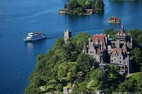 Boat cruising past Boldt Castle on the St. Lawrence River