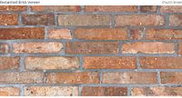 Close-up of reclaimed brick veneer panel showing red and tan weathered brick and grey mortar lines