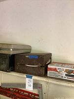 Stack of three vintage electronic units in cases on shelf