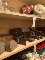 Shelf view showing cameras, binoculars, wooden box, bookends