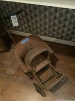 Top view of wicker baby carriage showing hood, bassinet and wheels