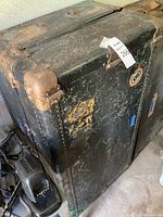 Overall view of metal steamer trunk showing size, color, and corner reinforcement