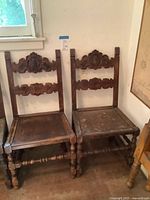 Front view of both antique carved chairs
