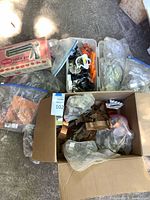 Overview of boxed Wear-Ever cookie press and multiple bags and trays filled with metal and plastic cookie cutters