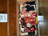 Drawer view showing nine vintage dolls in assorted international costumes