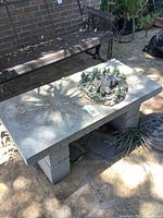 Concrete bench with miniature house decor on top