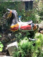 Full view of painted carousel horse in outdoor setting