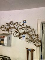 Full view of gold-tone metal wall candelabra mounted on wall