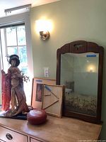Group shot showing geisha doll, two framed artworks, mirror edge and red decorative piece