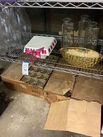 Shelf with Libbey goblet boxes, glass vases, gold-tone bowl, covered dish