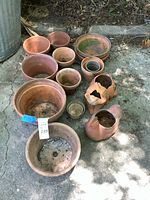 group of 13 terracotta and ceramic planters on ground