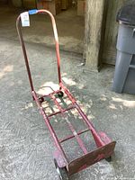 Full view of red metal hand truck showing structure and wheels